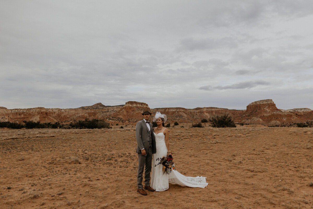 vintage styled bride and groom  standing in the desert