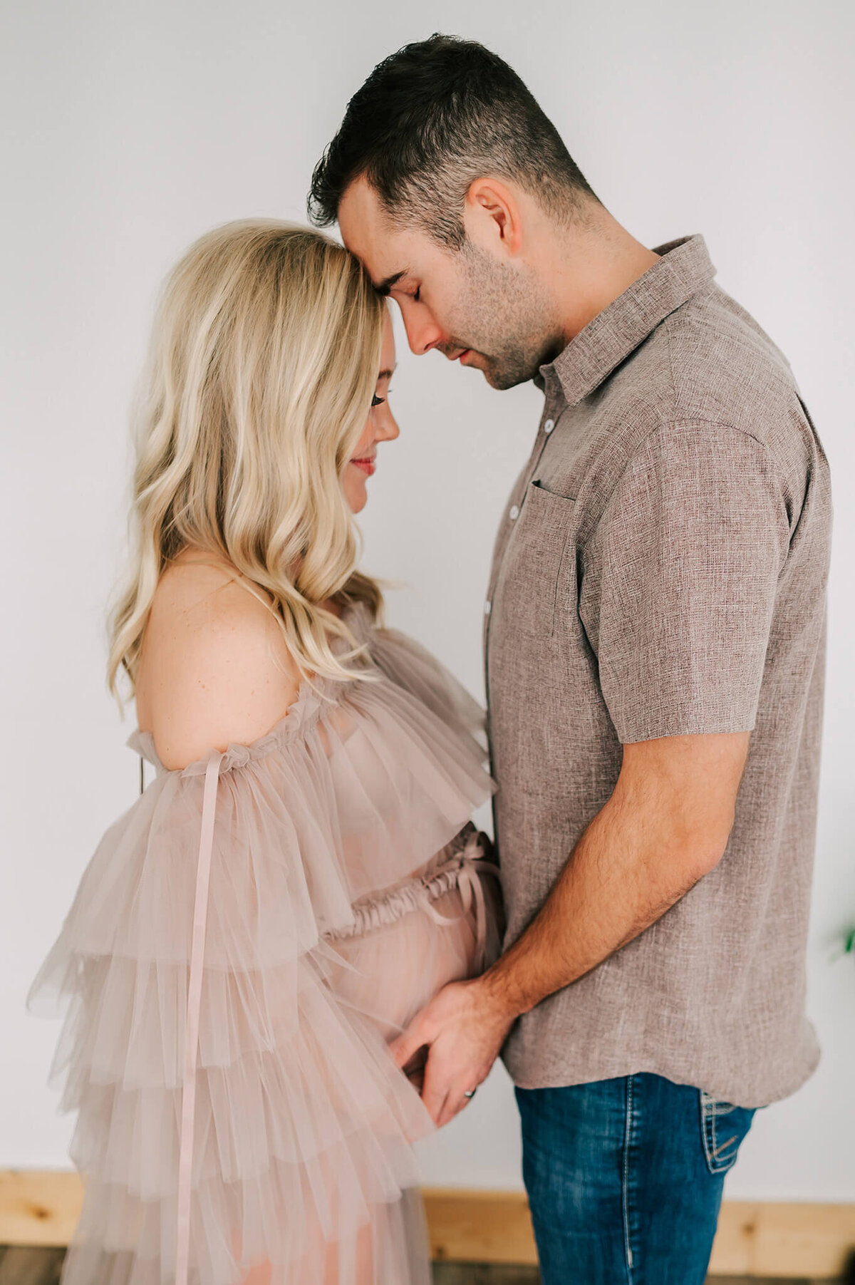 Springfield MO maternity photographer captures pregnant couple touching forehead holding baby bump