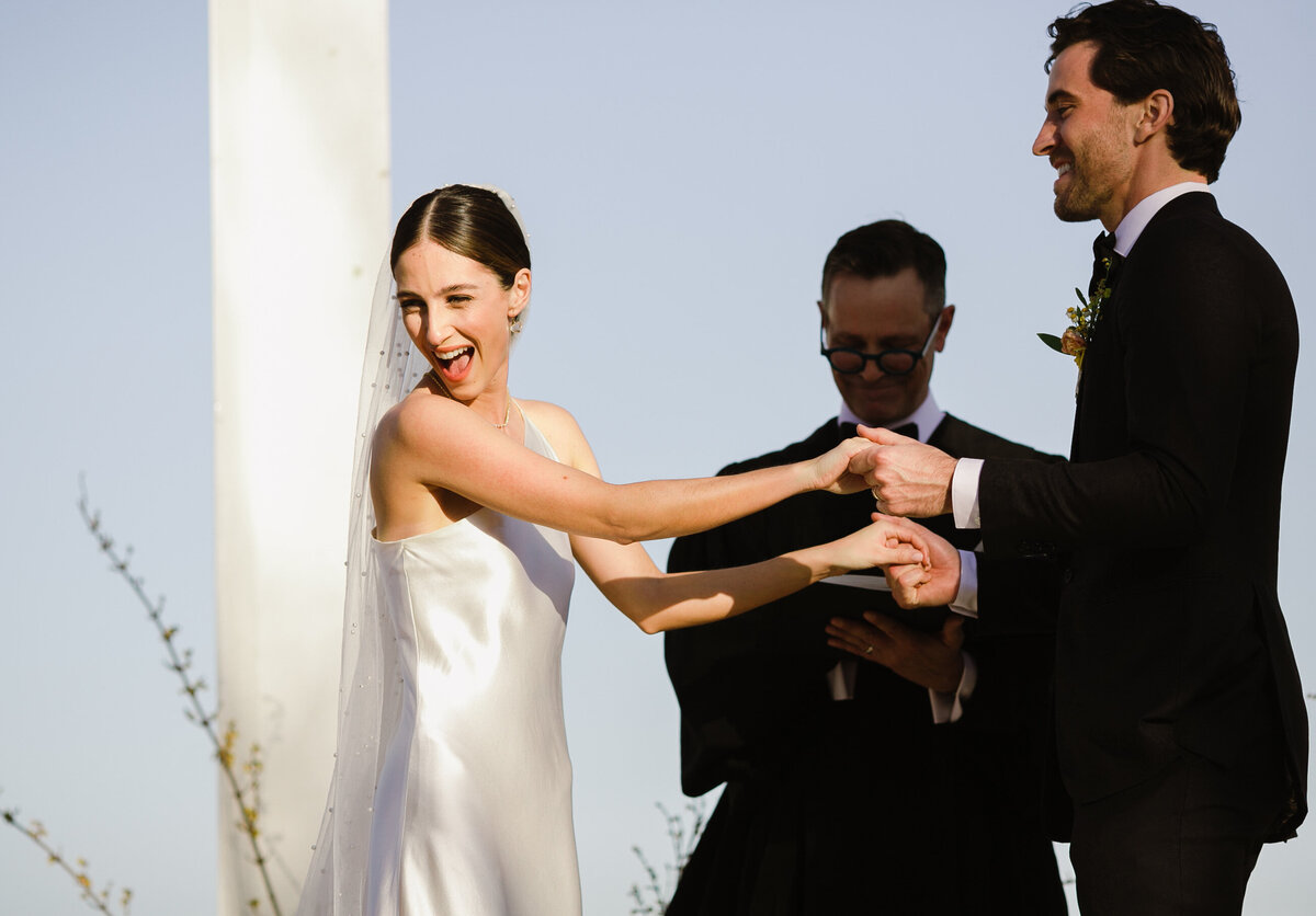 Bride and groom holding hands at outdoor wedding ceremony at Prospect House, Austin