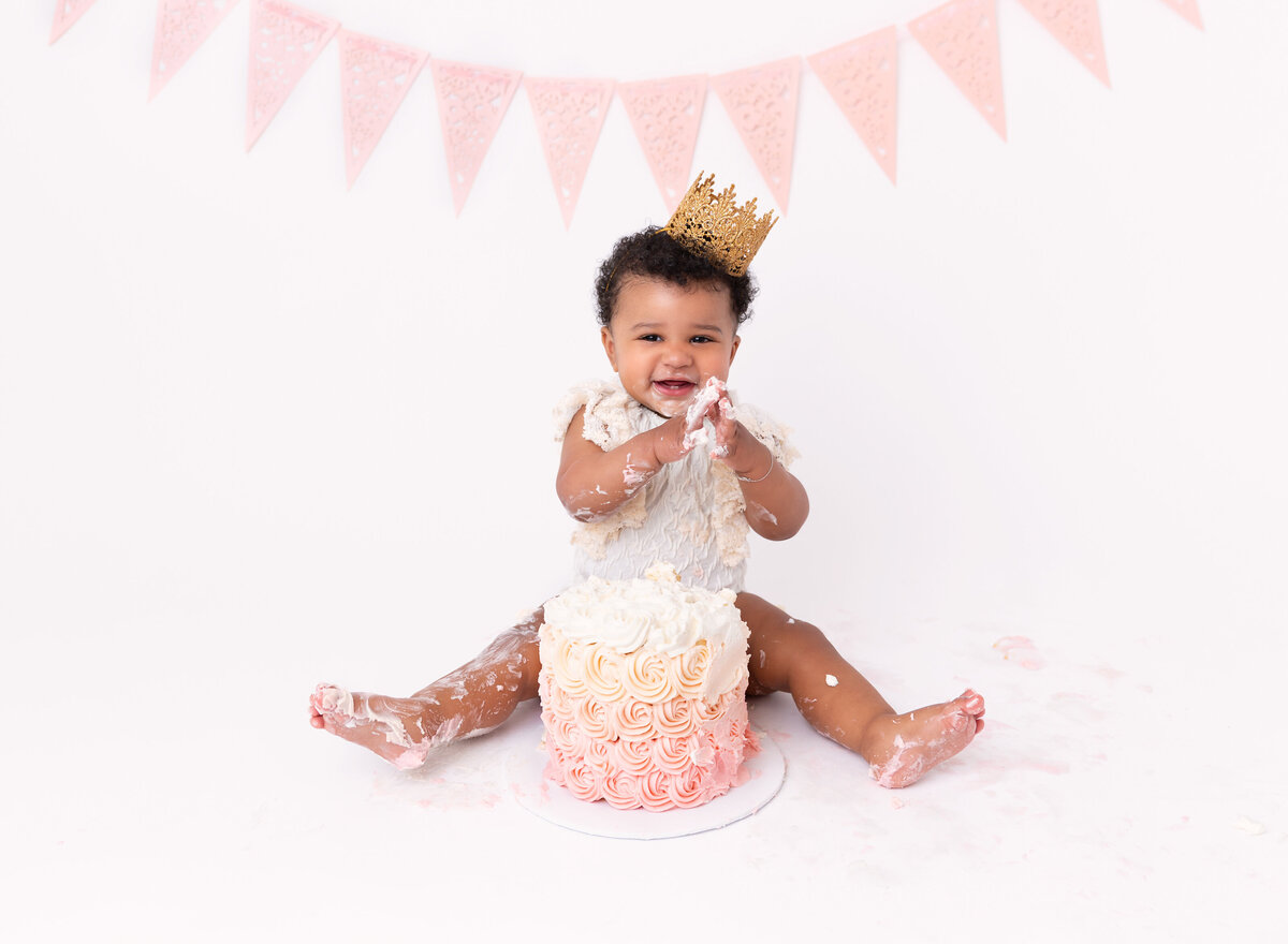 baby girl at her cake  smash  photolesion pink and cream color setup Done by Rochel Konik photography