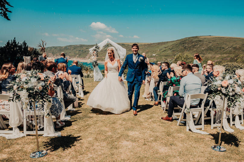 A bride and groom walking down the aisle