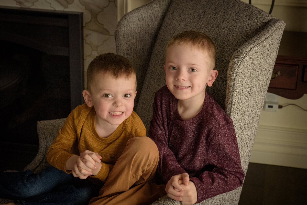 Two young brothers sitting in chair wearing yellow and maroon in their home in Green Bay, Wisconsin.