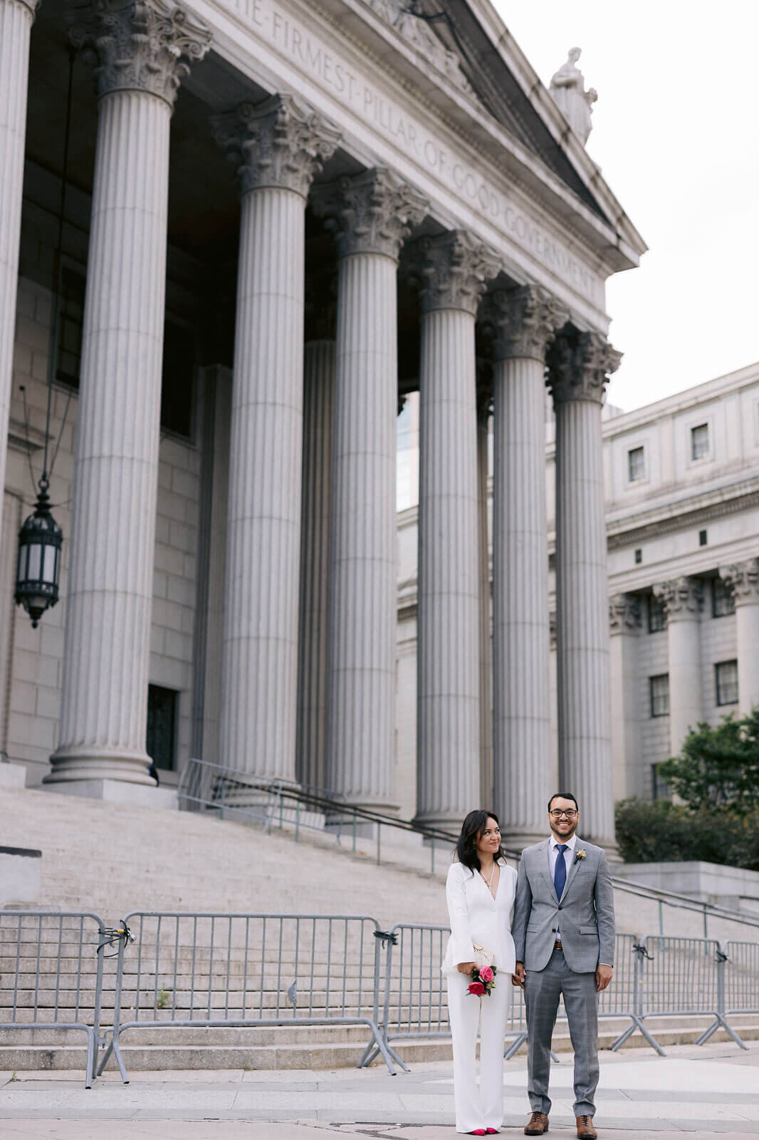 The bride and groom are outside the NY City Hall. Image by Jenny Fu Studio