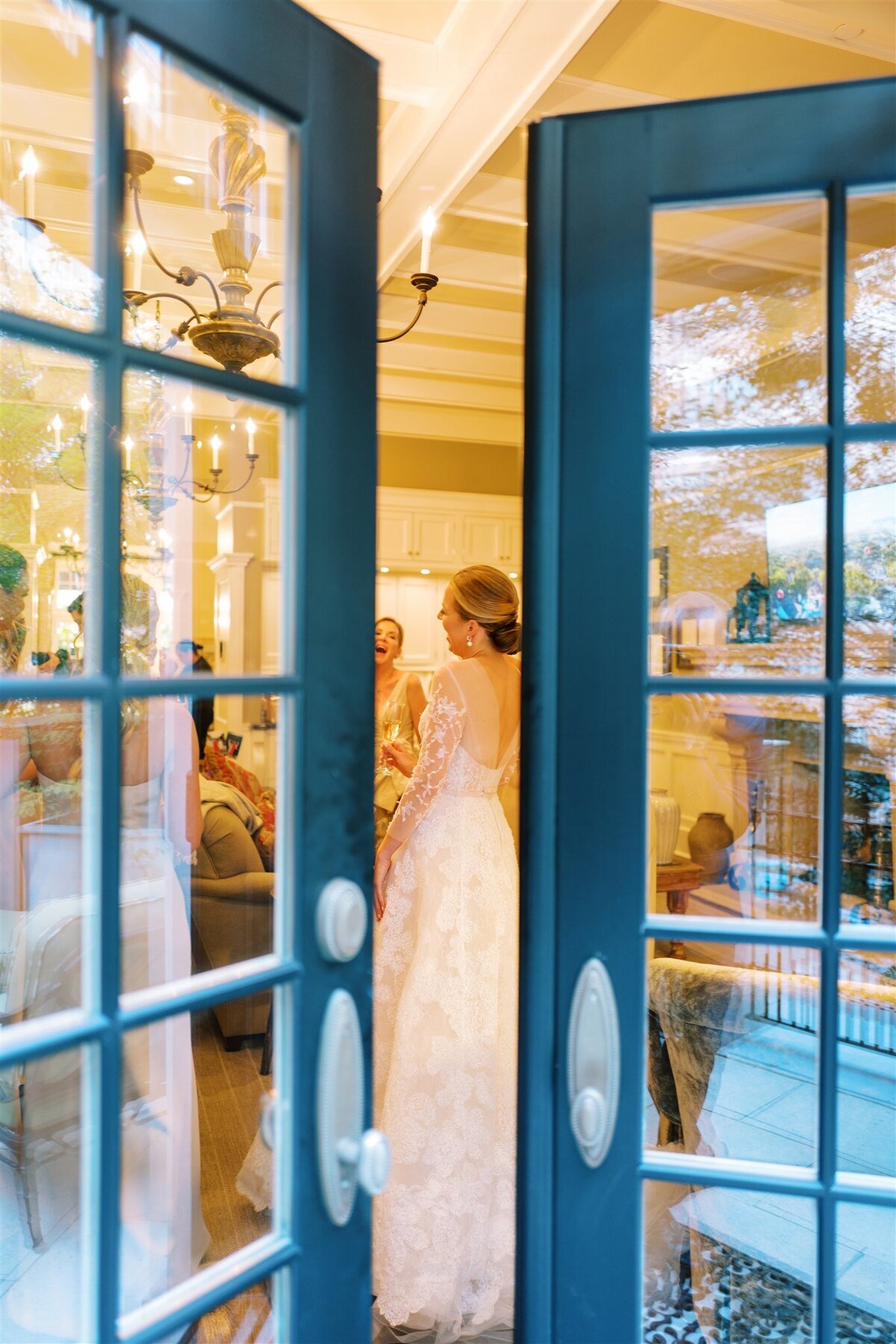 A picture of the bride through some paned glassed doors. 