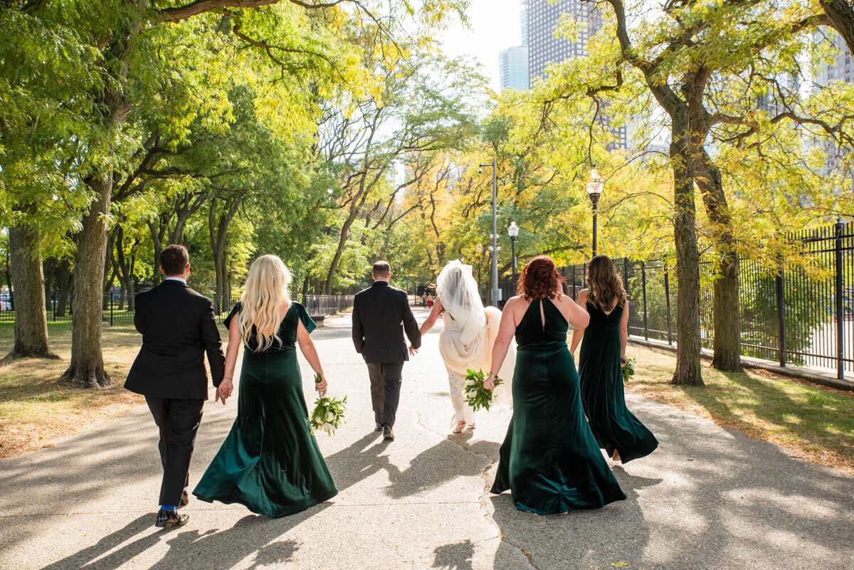 A bride and her bridesmaids are walking down a path