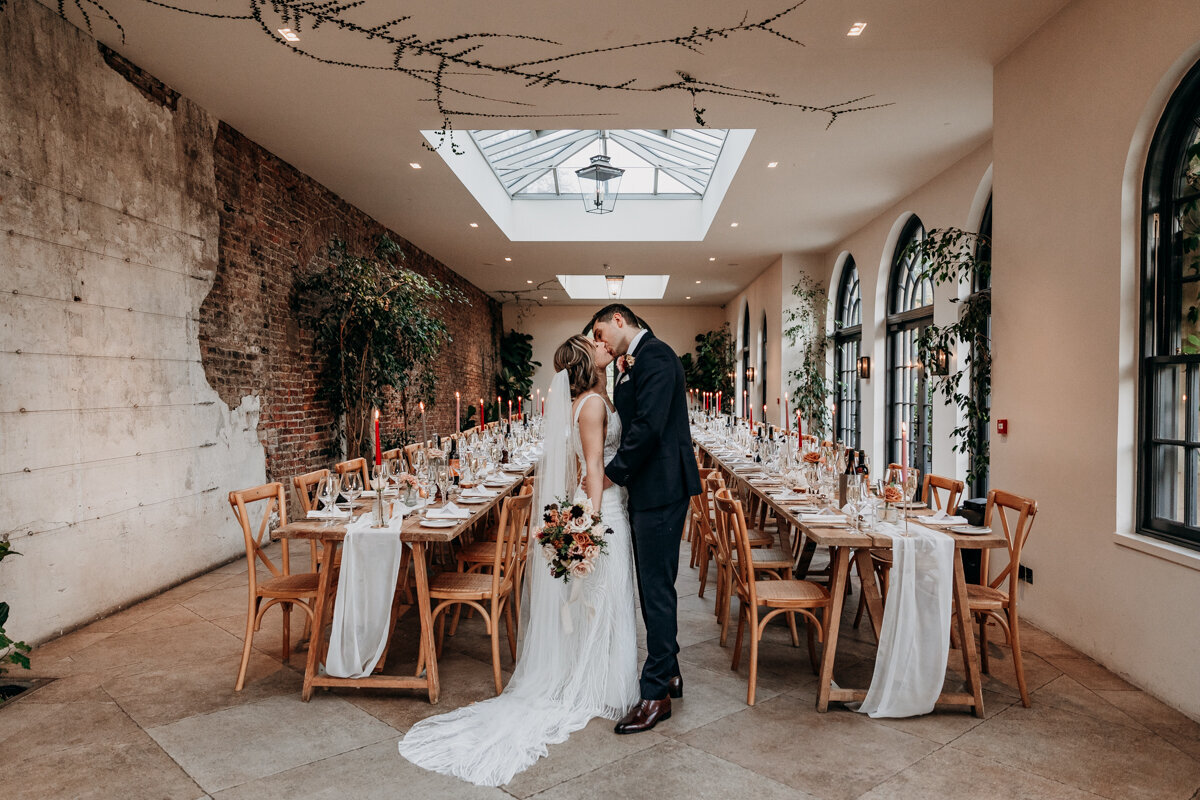 Bride and groom kissing in The Fig House Middleton Lodge