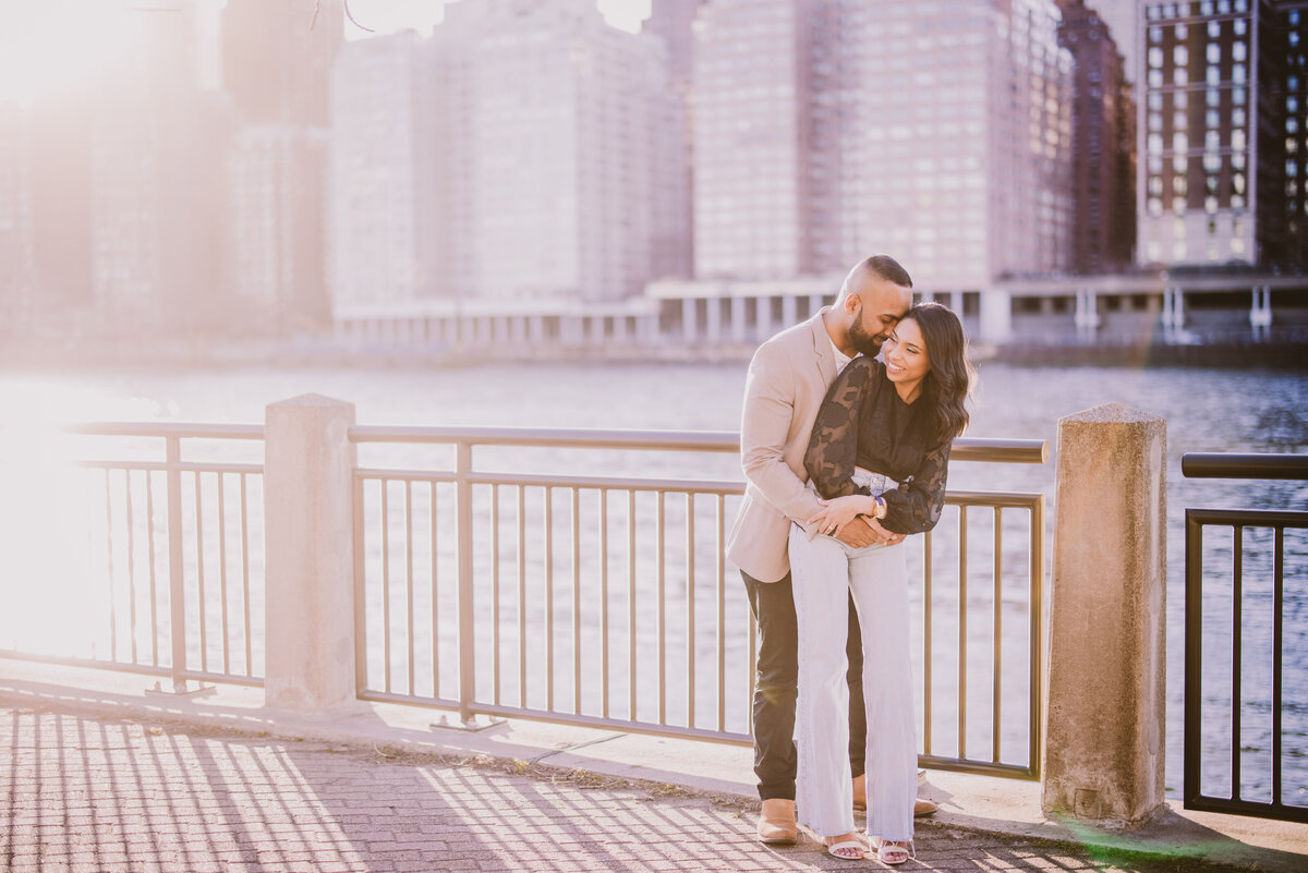 A couple embracing at the promenade at roosevelt island in nyc during their engagement session