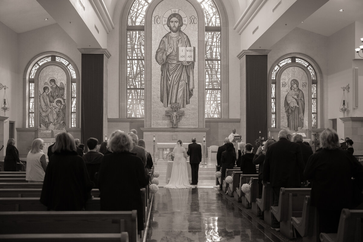 Bride and Groom holding hands at the start of their nuptial Mass in front of the altar at St. Joseph Husband of Mary Catholic Church in Las Vegas