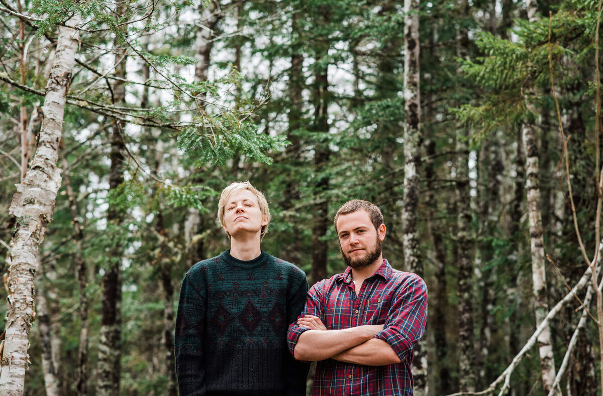 Couple standing in forest.