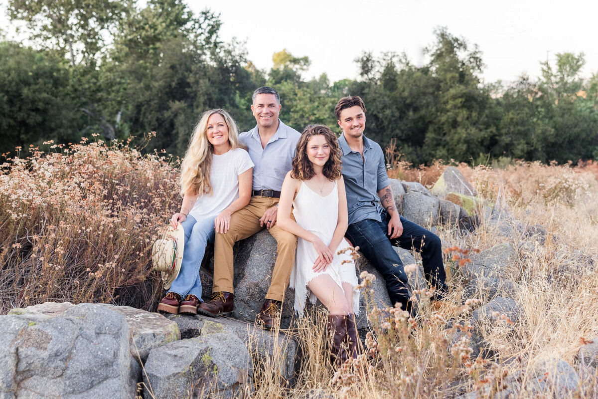 family sitting on rock field of tall grass san diego