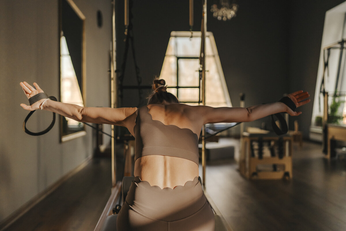 The Pilates house owner posing and logo overlaying the photo