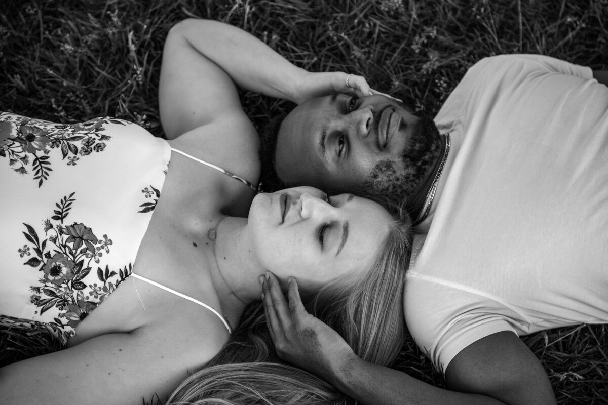 engaged couple lay in grass in phoenix