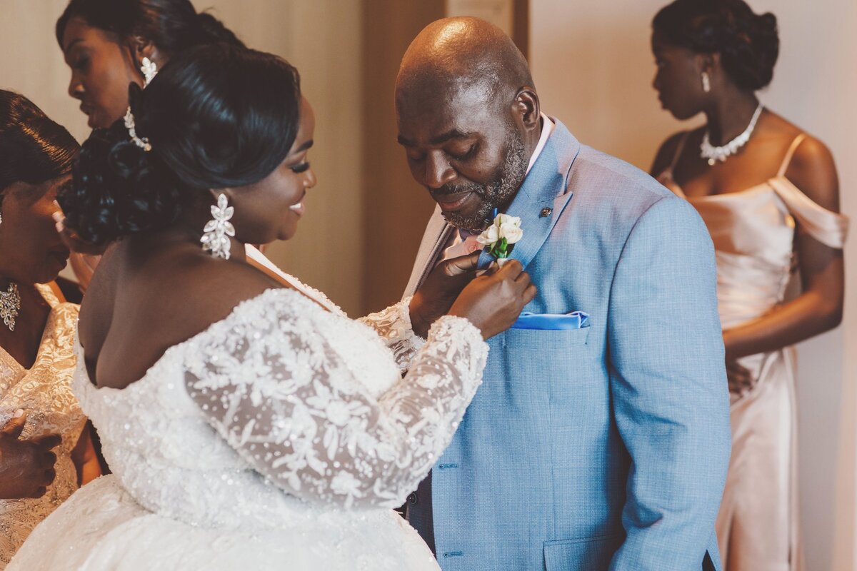 Bride putting boutonnière on father at Cancun wedding