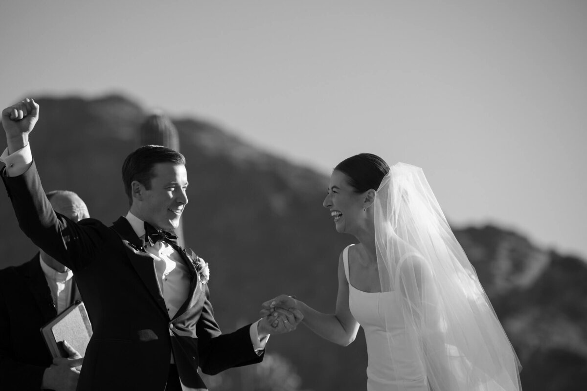 Bride and groom celebrating joyfully after their ceremony at Mountain Shadows, captured by wedding photographers in Phoenix.