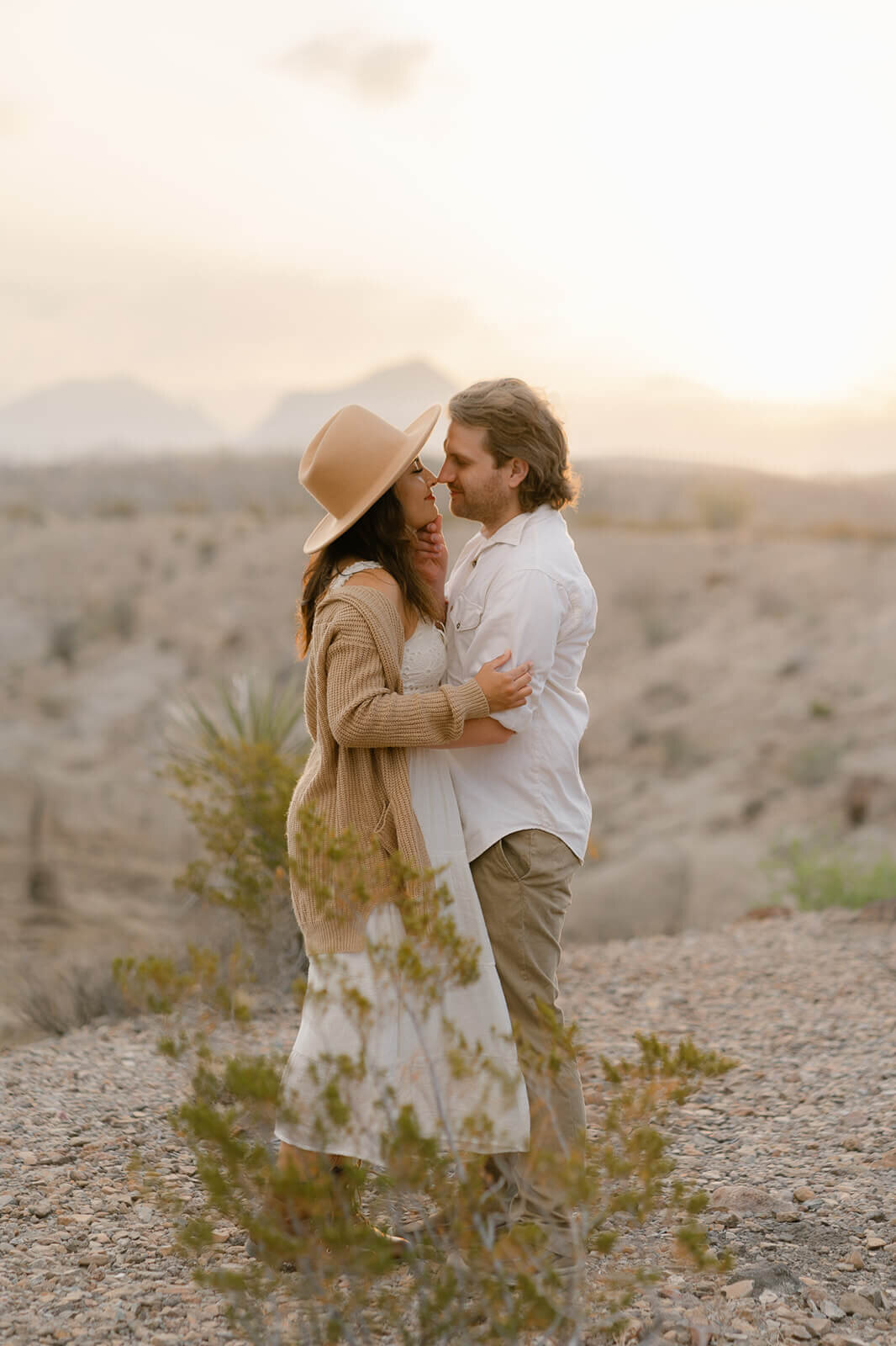 husband and wife hold eachother in desert landscape