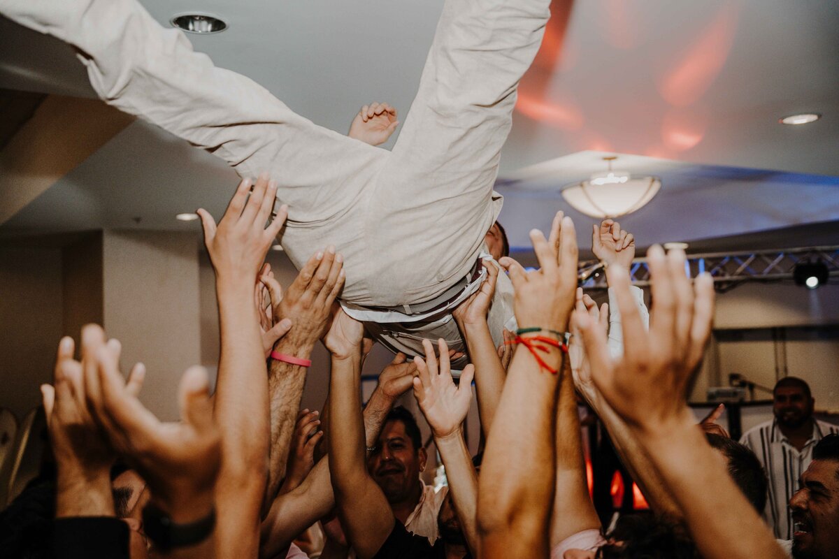 groom thrown in the air during his wedding reception
