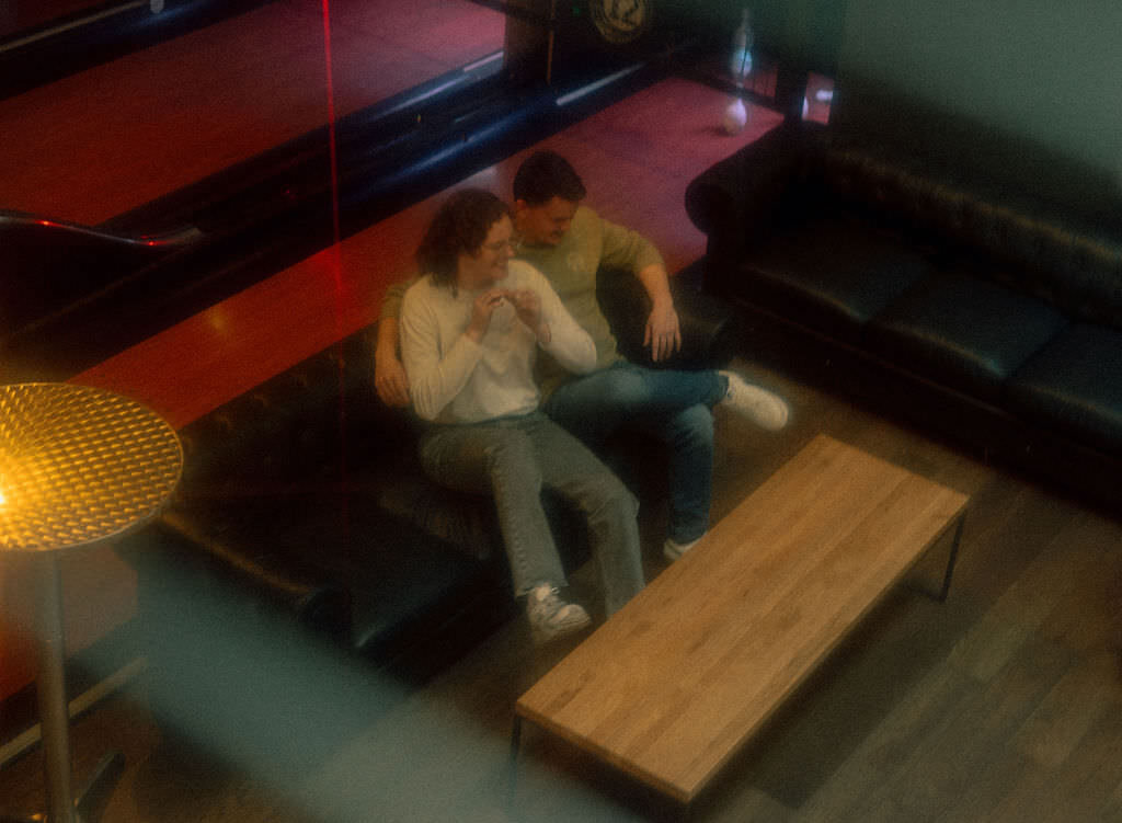 A couple sitting on a leather couch together.