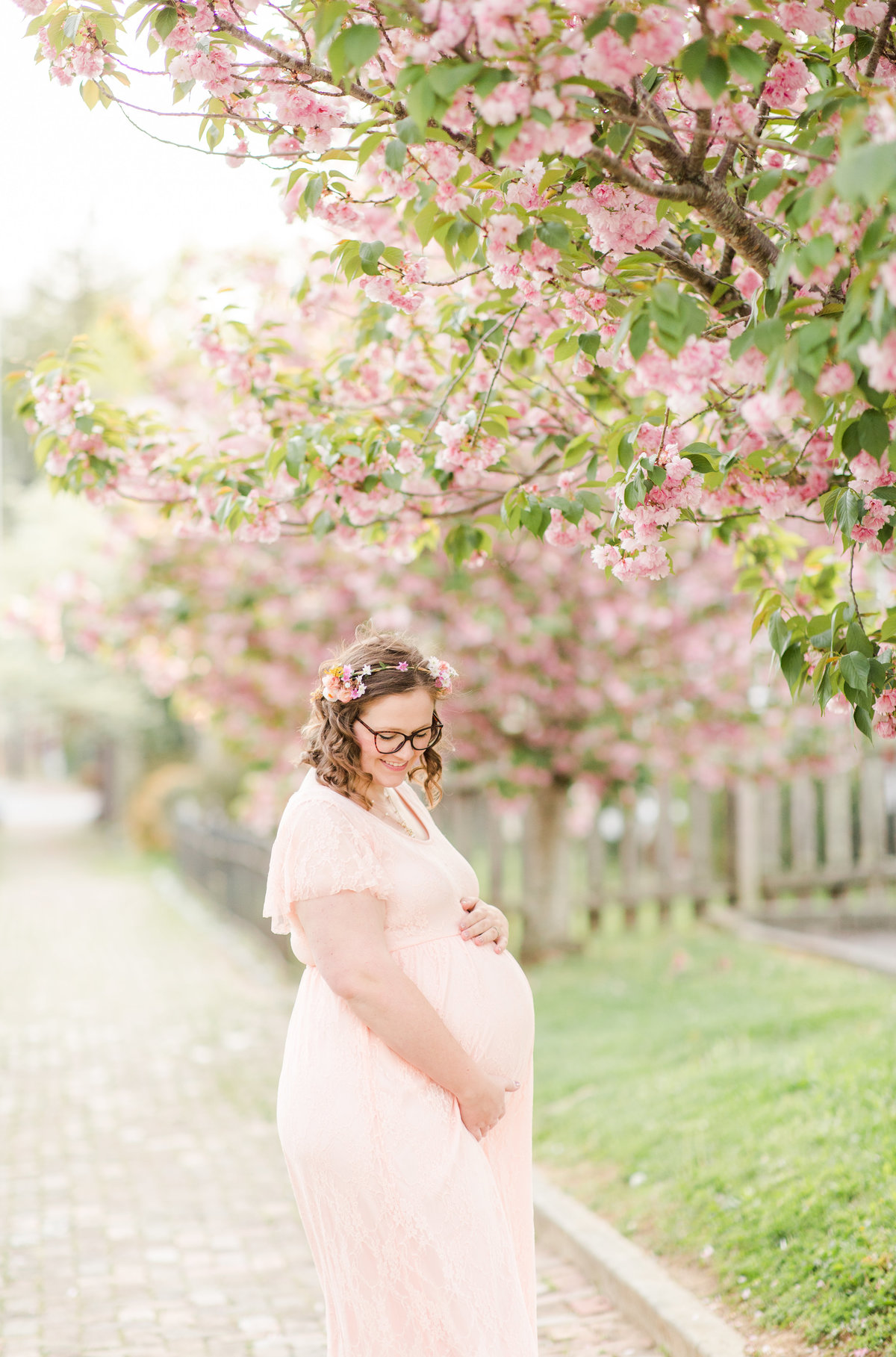 Gorgeous expecting mother poses with the cherry blossom trees