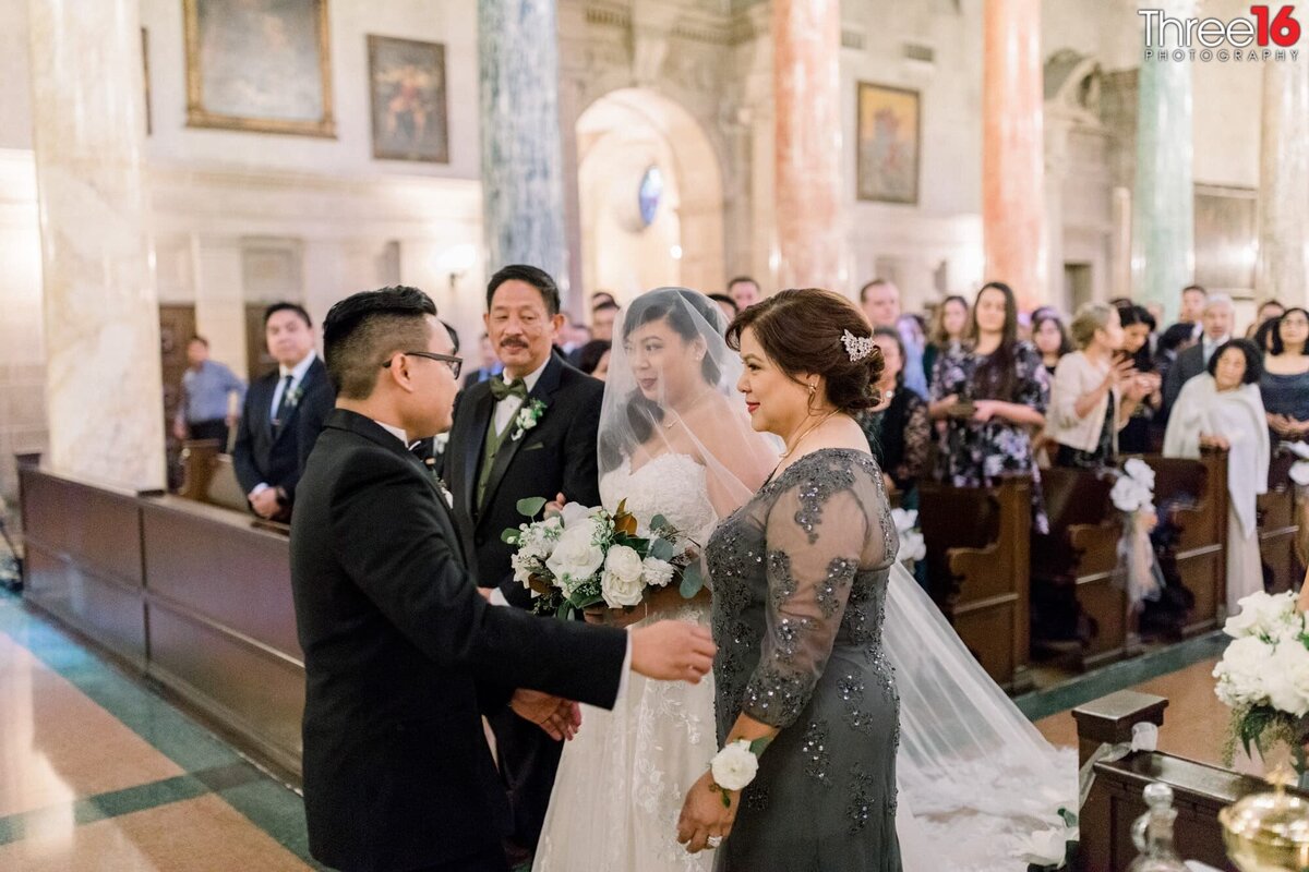 Bride's parents hand off their daughter to the Groom at the altar