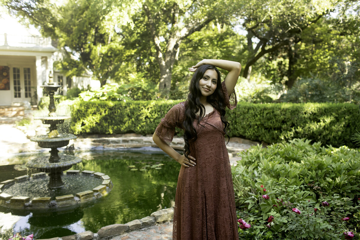 A senior looking confident and poised as she stands amidst the elegant garden landscape of Chandor Gardens, celebrating the end of high school and the start of something new.