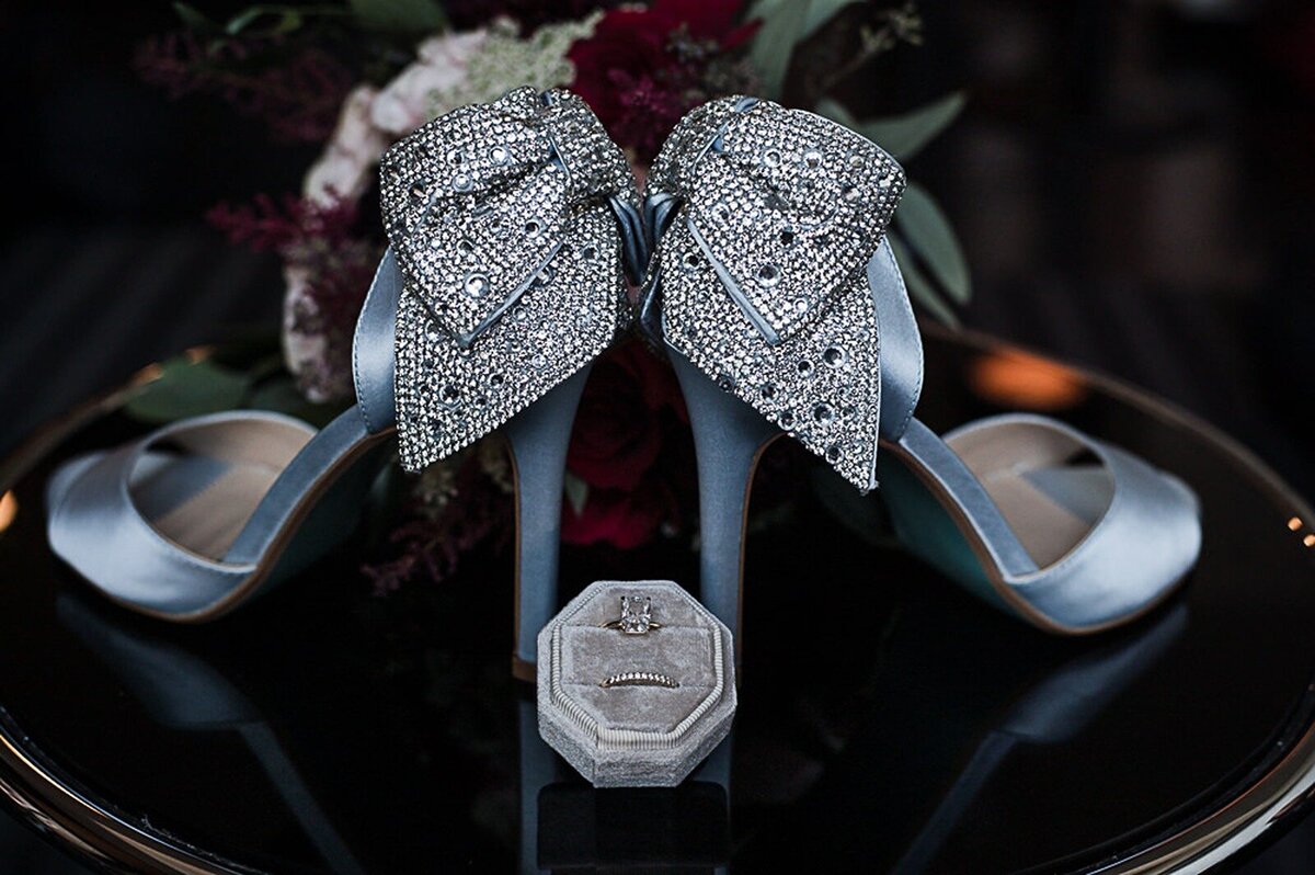 Wedding detail picture of blue shoes and wedding ring.