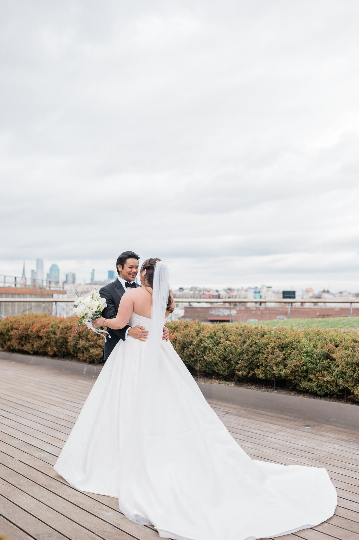 Newlyweds embrace and smile on an New York City rooftop