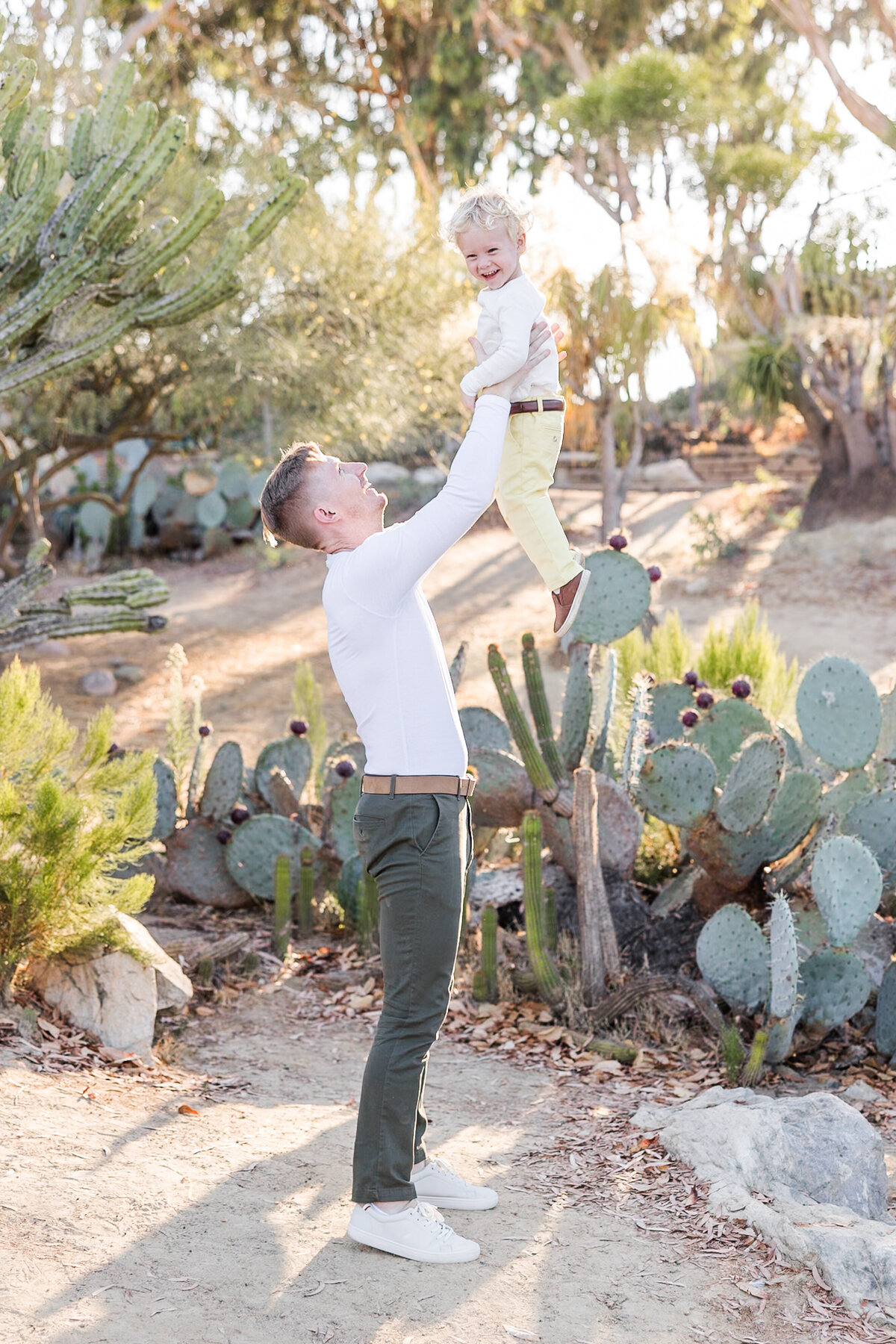 father holding up son in Cactus garden Balboa Park San Diego