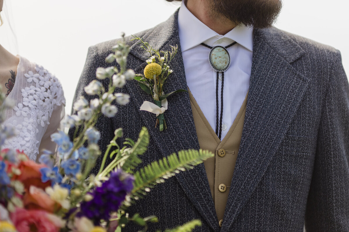 Details on groom with wedding bouquet