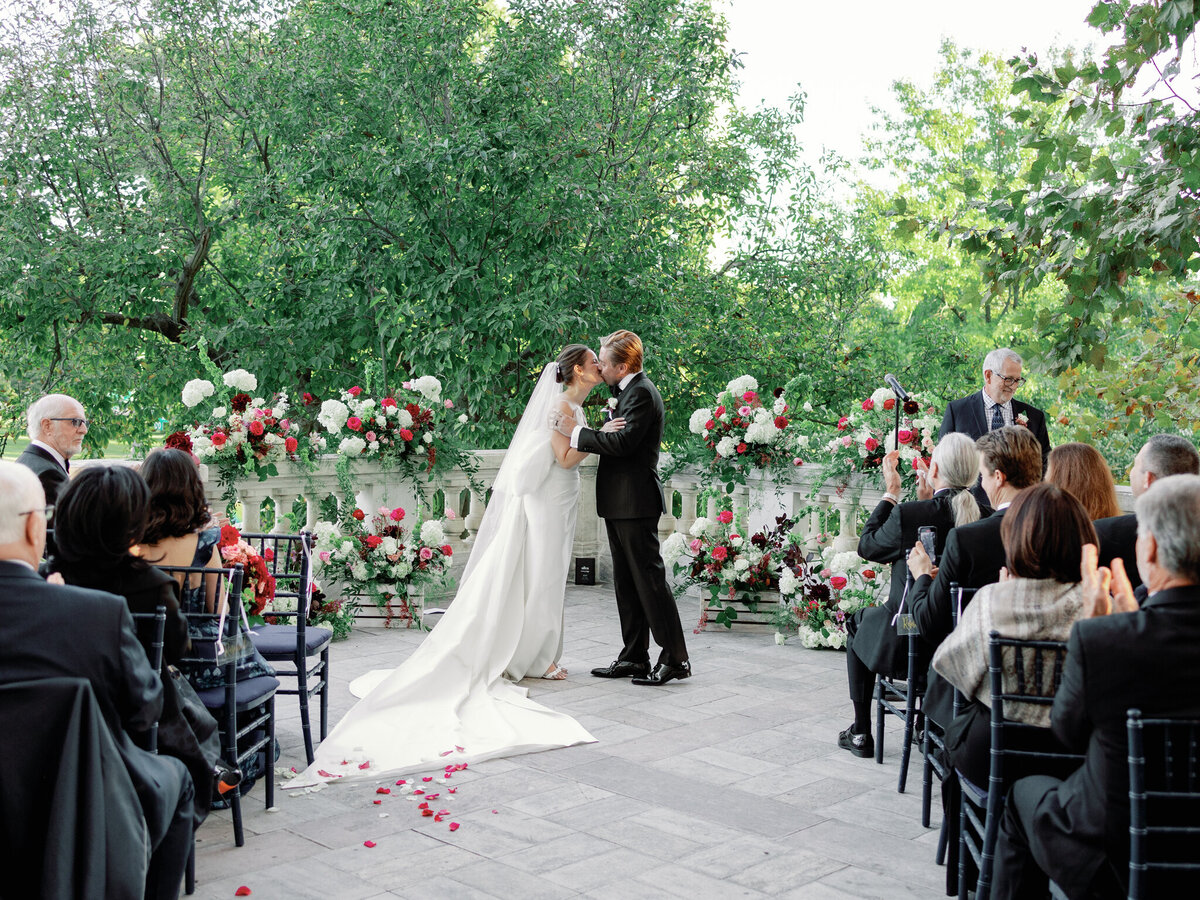 Bride and groom kiss on outside porch of DAR Constitution Hall