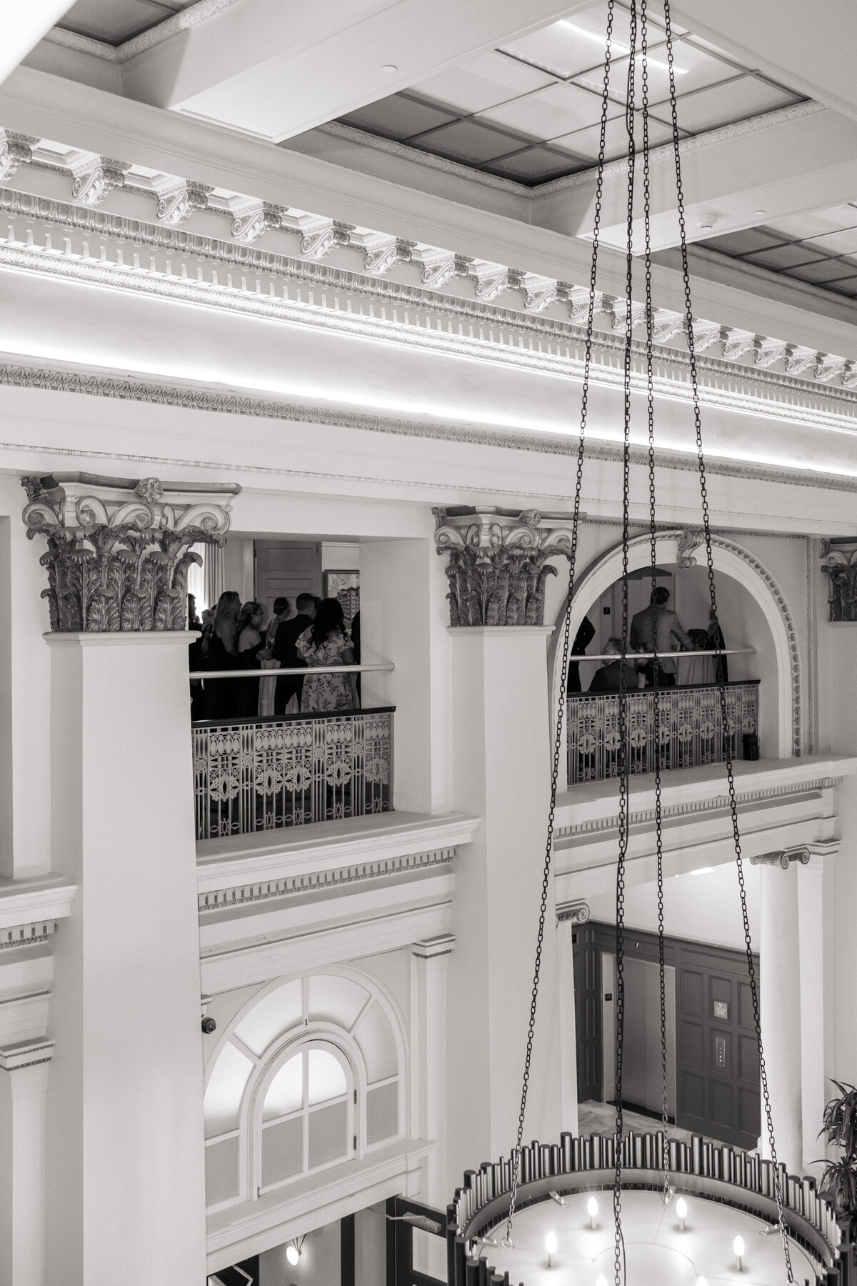 Balcony view of guests mingling in historic venue by Philadelphia wedding photographer.
