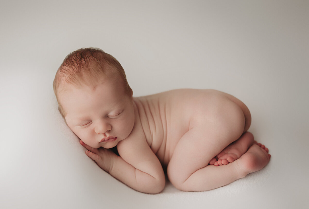 baby laying on white backdrop