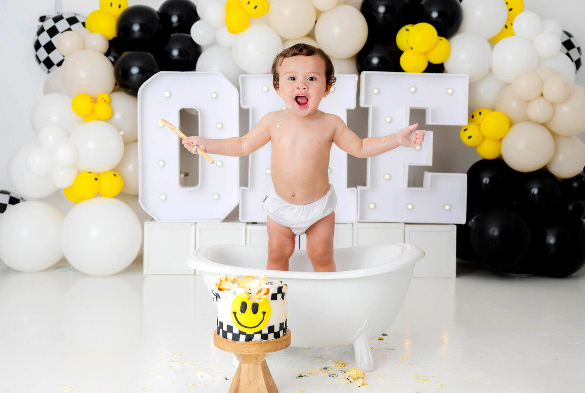 Boy standing in a mini tub with arms outstretched and a playful yelling expression.