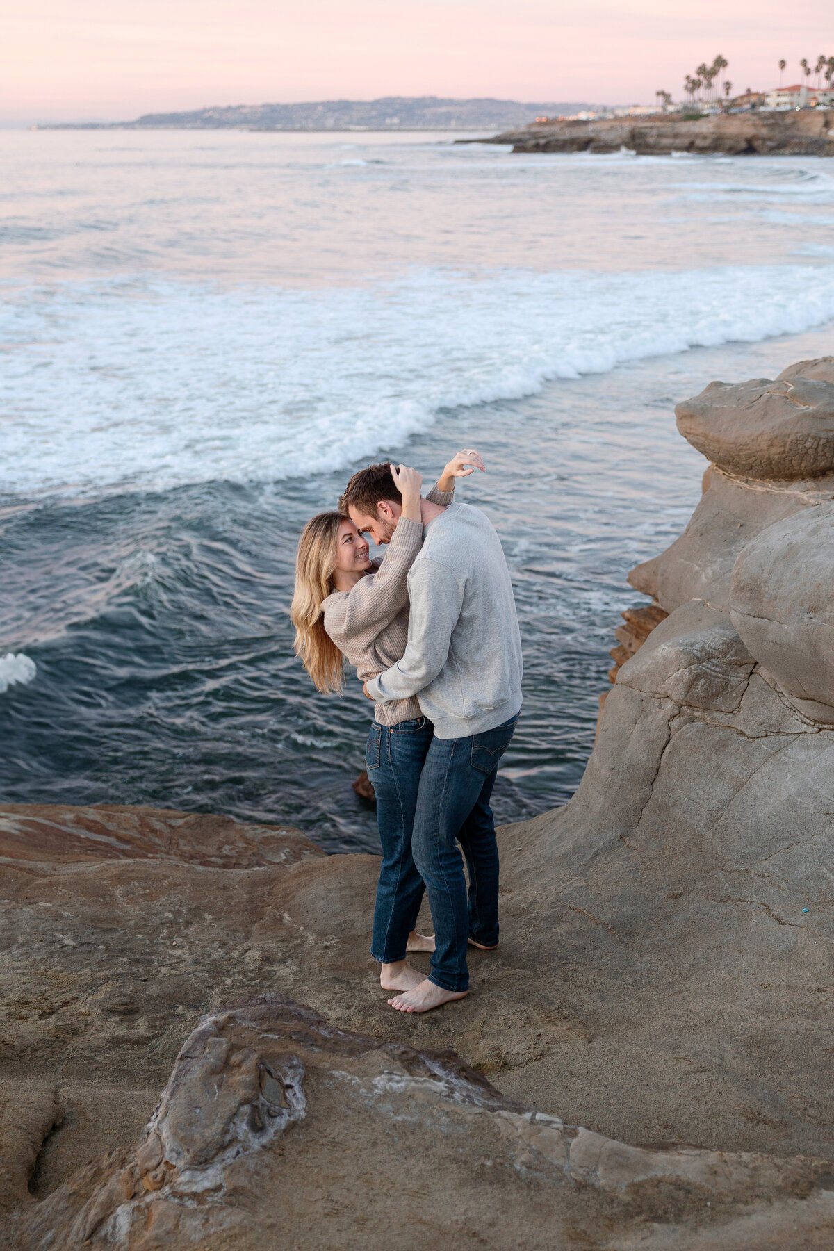 Elegant couple posing together with the coastline in the background, captured in a stunning portrait by a La Jolla wedding photographer.