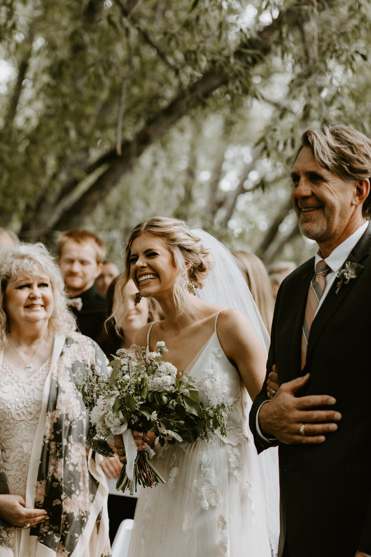 Documentary style image of bride smiling at her groom during wedding ceremony captured by Tim & Court Photo and Film, joyful and adventurous wedding photographer and videographer in Calgary, Alberta. Featured on the Bronte Bride Vendor Guide.