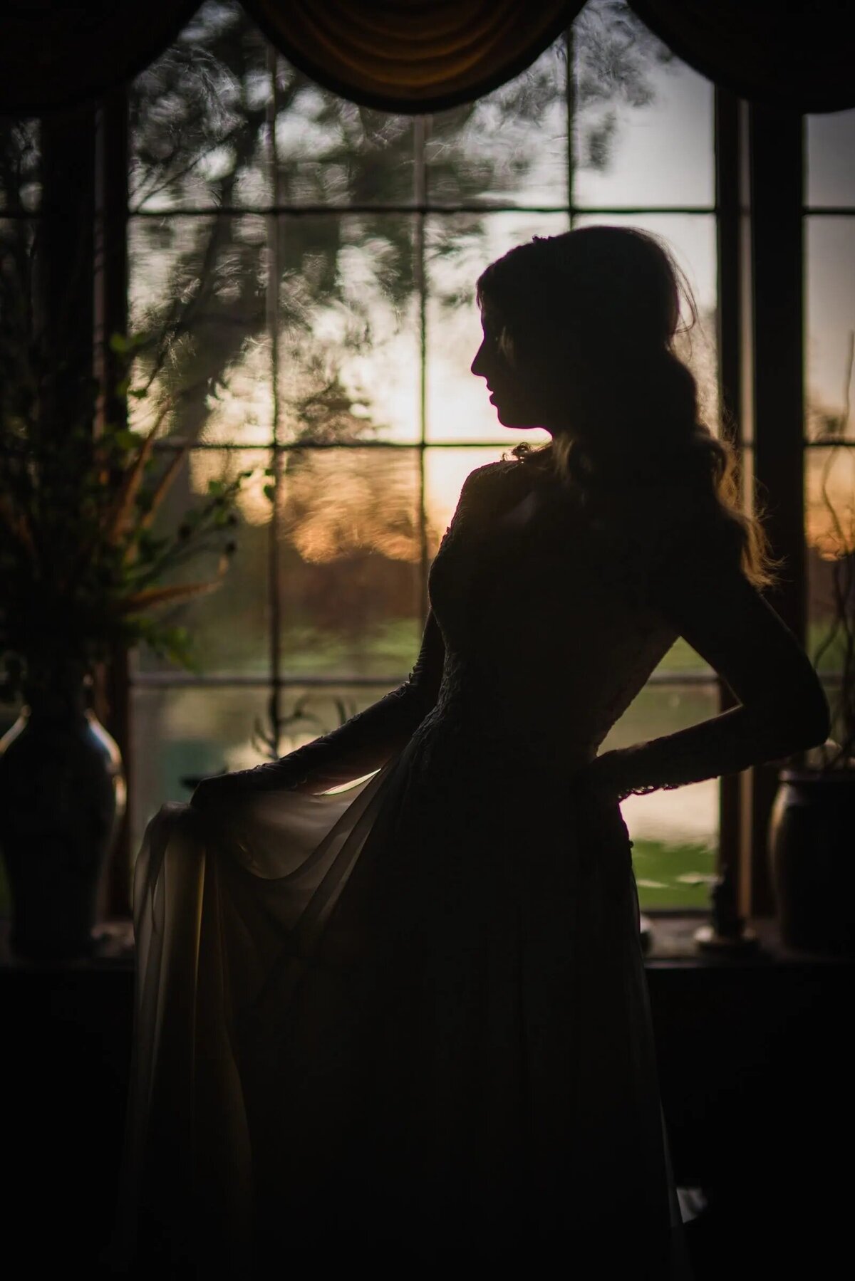 The silhouette of a bride in a window