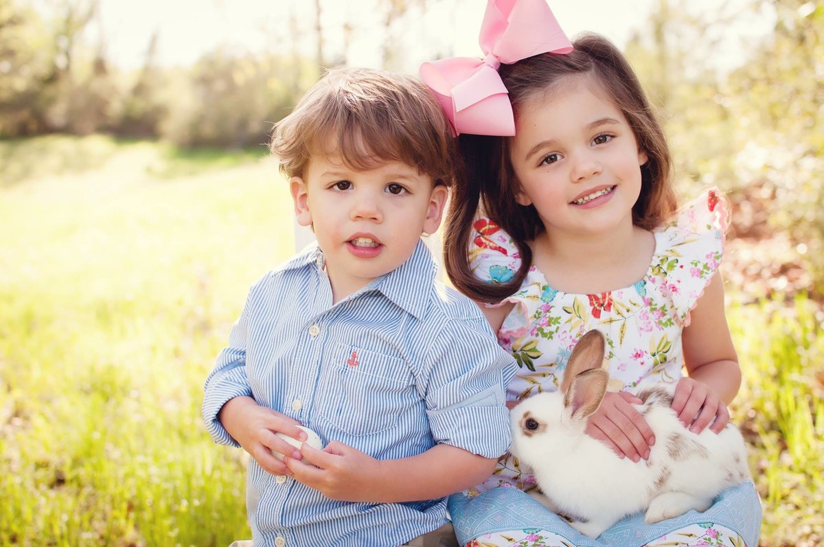 Heartwarming Easter portrait of children holding a bunny in Ida, LA by Sarah Farmer, capturing timeless memories.