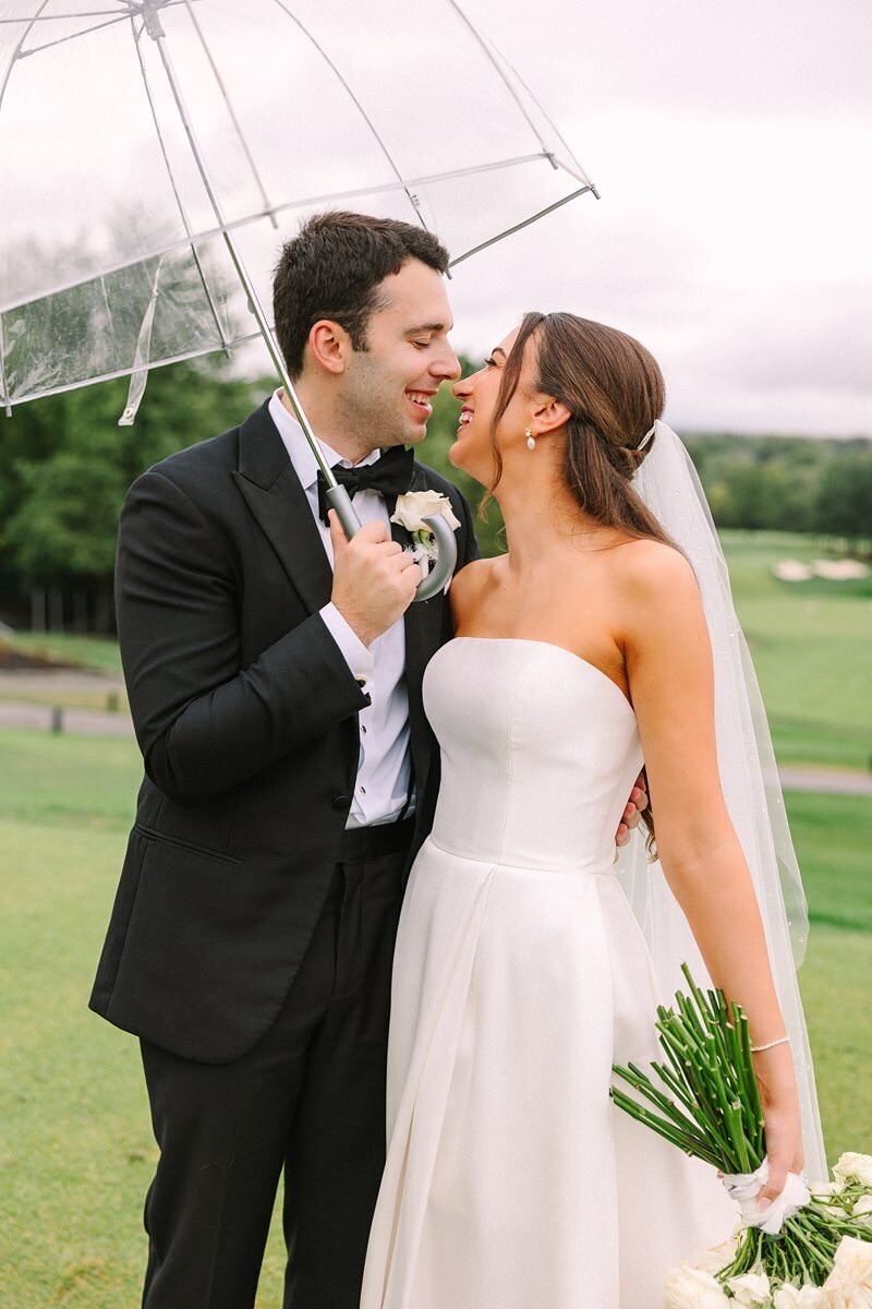 bride-and-groom-rainy-umbrella-evansville-country-club11