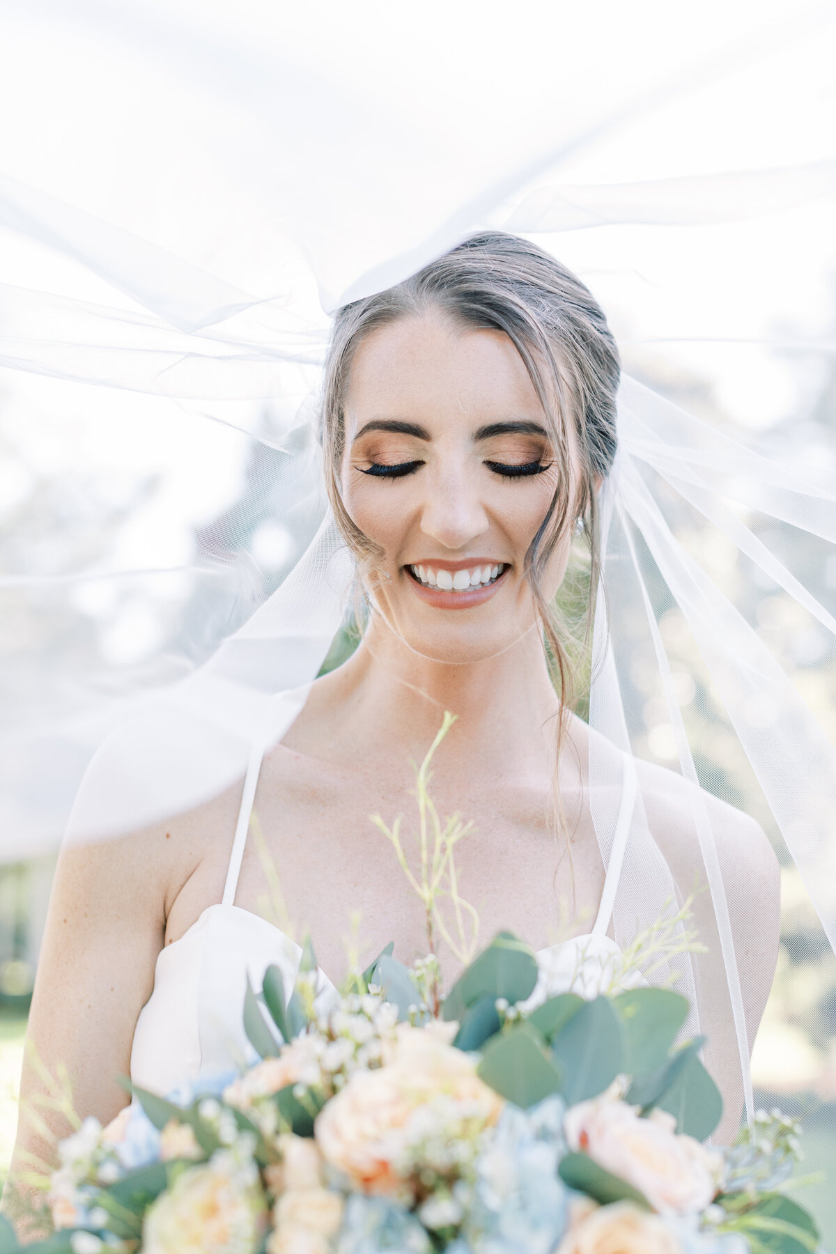 A bride laughs under the veil.