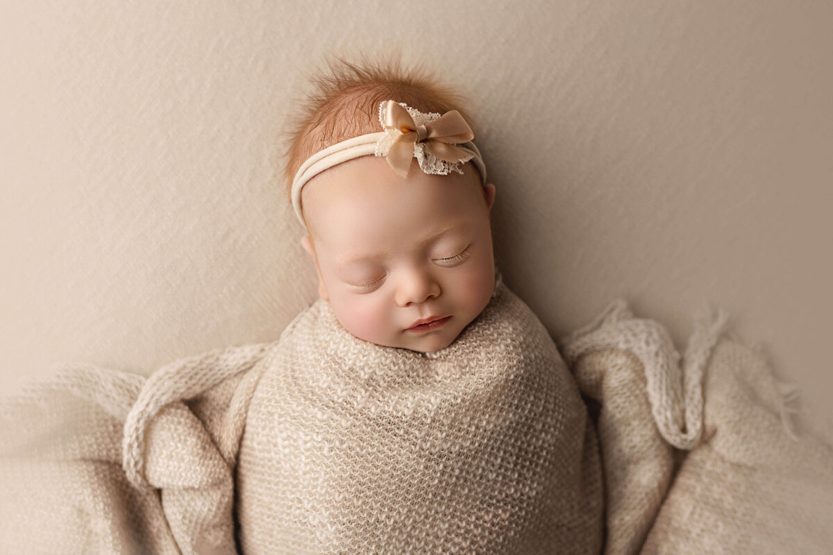 Newborn Girl Wrapped In Ivory Swaddle