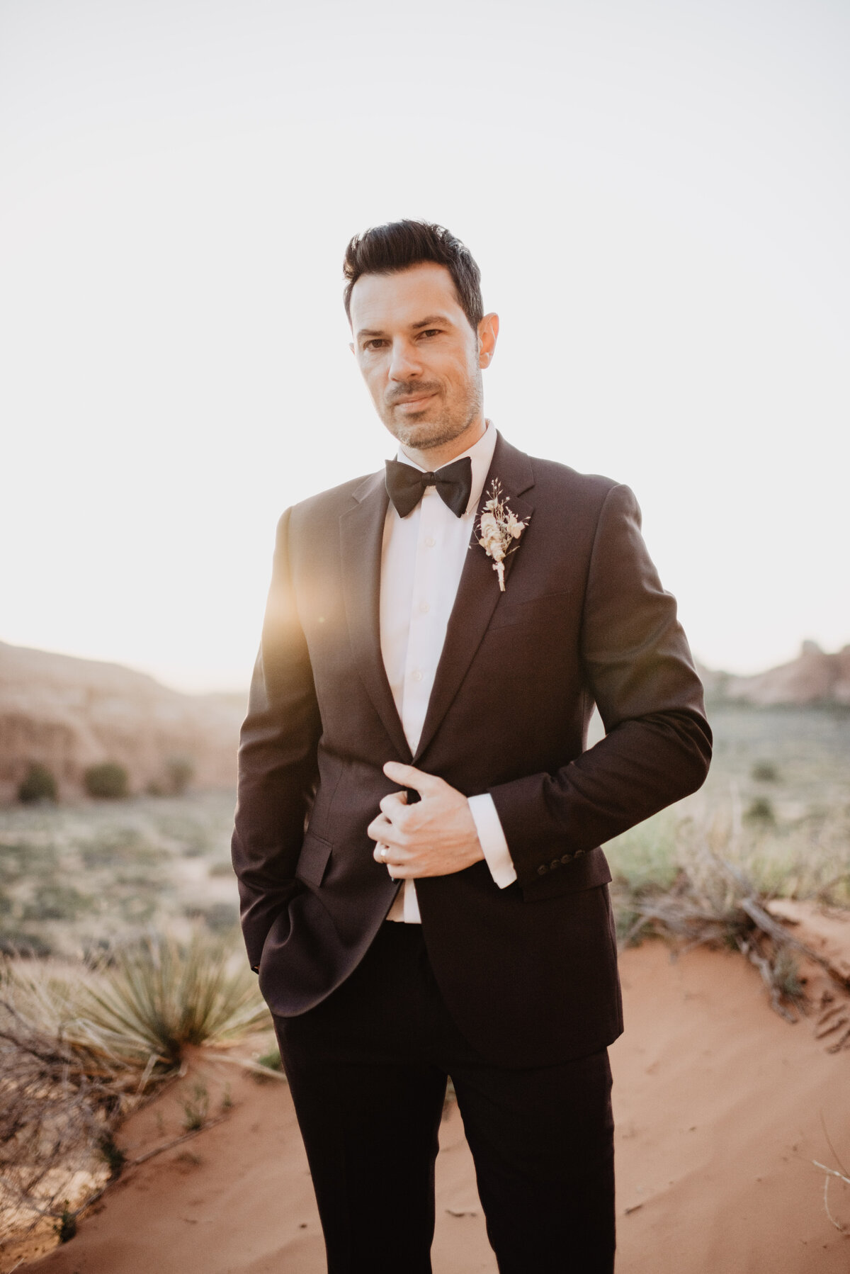 Utah elopement photographer captures groom adjusting jacket