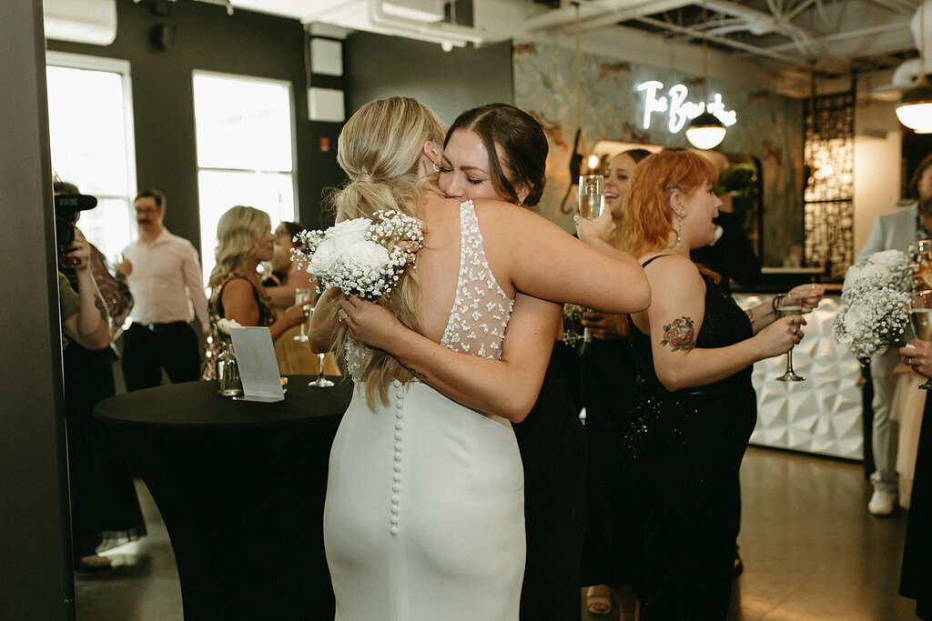 Bride hugging wedding guest by Court Amber Photography, joyful and adventurous wedding photographer in Calgary, Alberta. Featured on the Bronte Bride Vendor Guide.