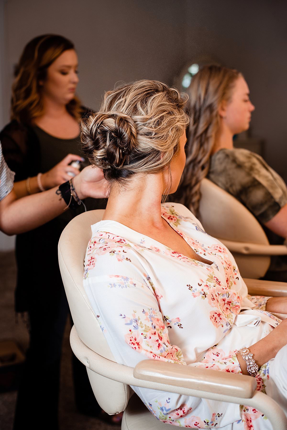 Bride sitting in chair having her hair done