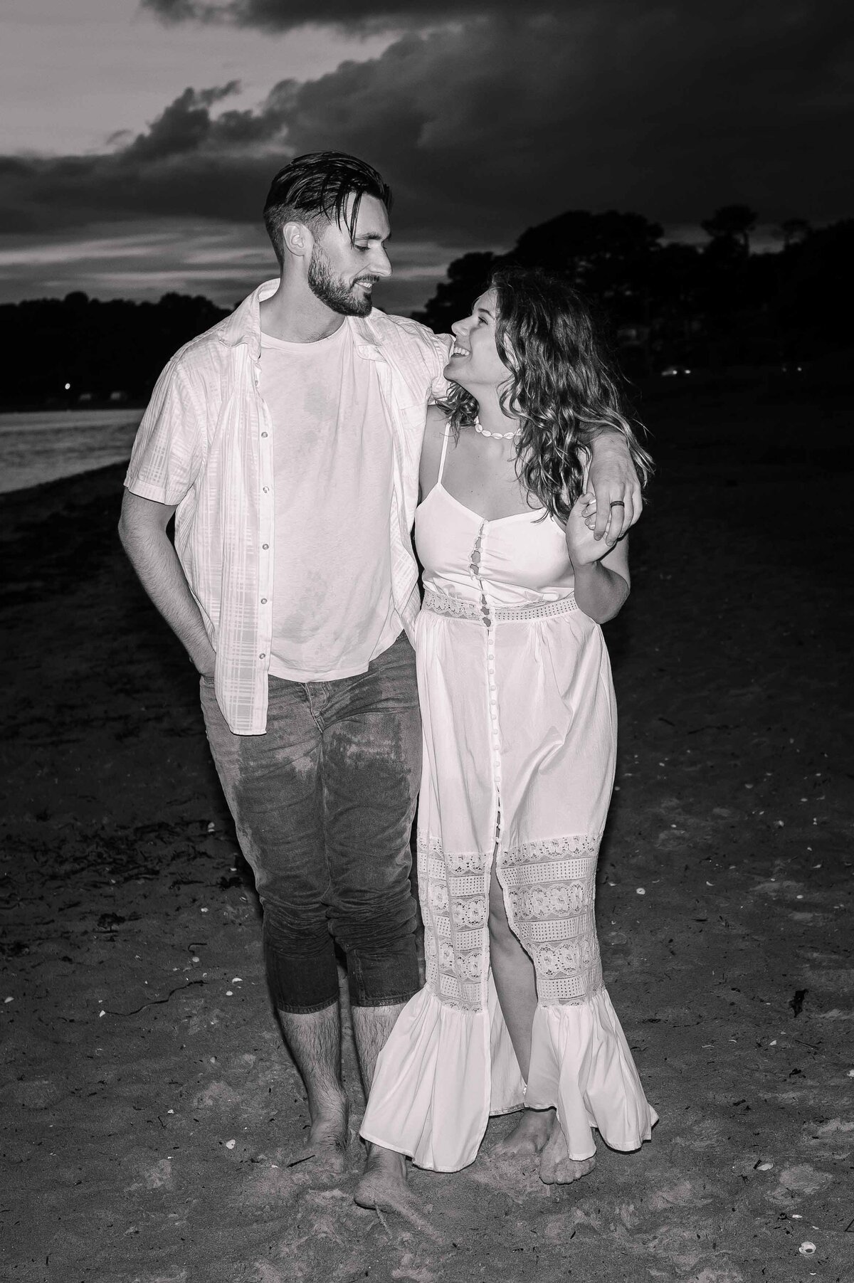 A black and white direct flash couple portrait on the beach