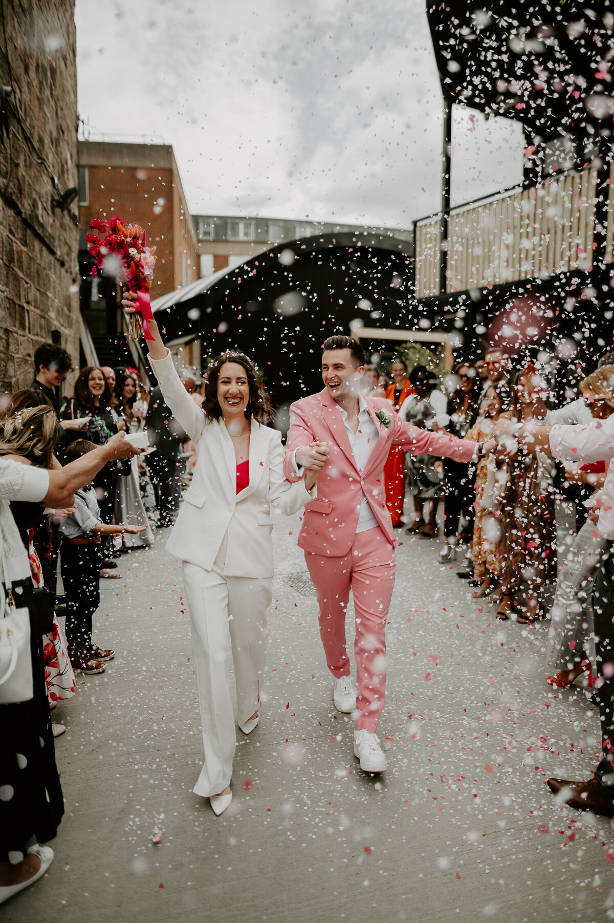 A bride and groom are showered by confetti as they exit their ceremony at The Shack Revolution.