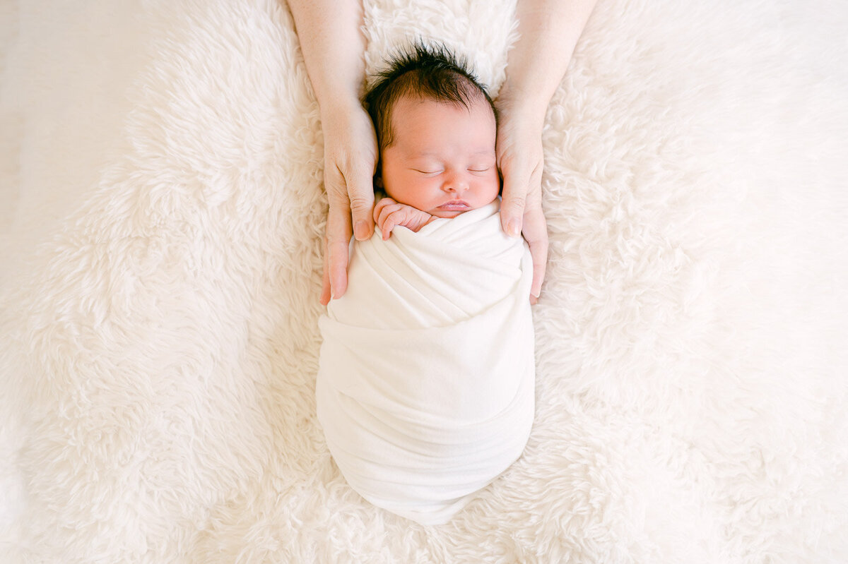 2023-newborn-wrapped-baby-girl-moms-hands
