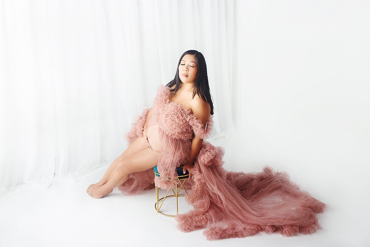 women wearing pink maternity gown with glam makeup during maternity photoshoot in Brentwood Tennessee photography studio