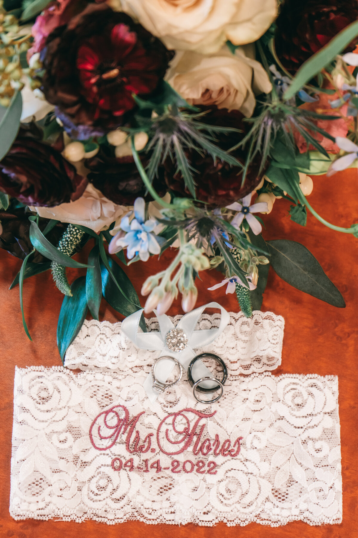 Wedding details, flowers, rings, and garter. Photo by 4Karma Studio