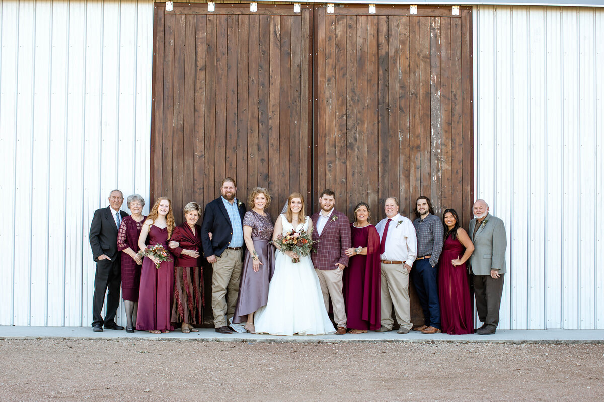bride and groom stand with family on each side at Allen Farmhaus in New Braunfels Texas