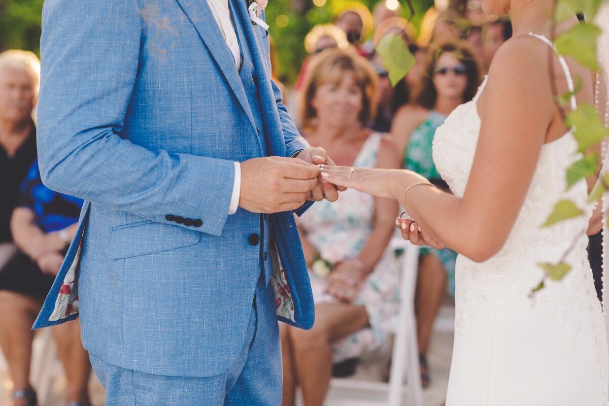 Groom putting ring on bride at wedding in Riviera Maya