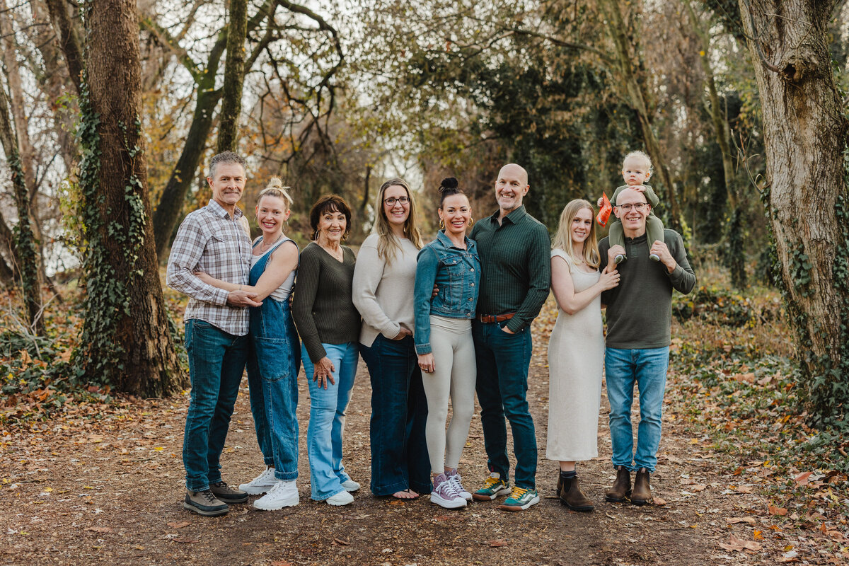 A family of nine smiles in a forest in Alexandria.